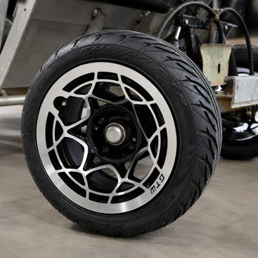 A close-up of a Fusion GTR golf cart tire mounted on a GTW Nexus wheel in black and machined finish installed on a Club Car DS golf cart. 